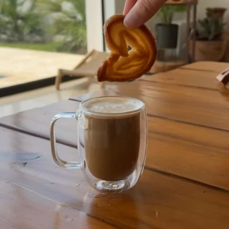 Una oreja a punto de mojarse en una taza de café con leche