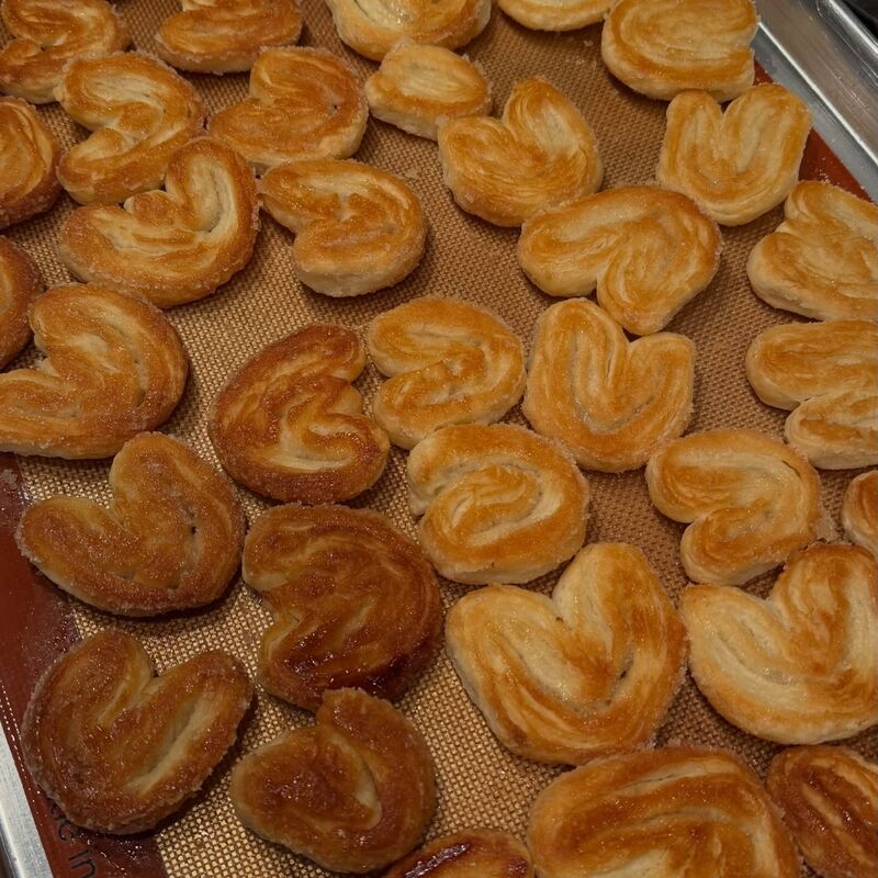 Una charola llena de orejas doradas recién salidas del horno
